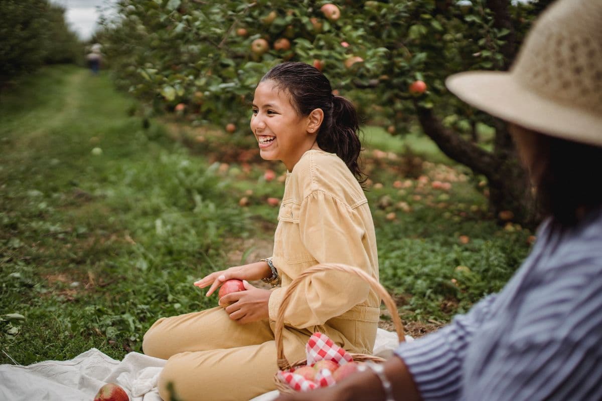 Teenager laughing outdoors in an orchard