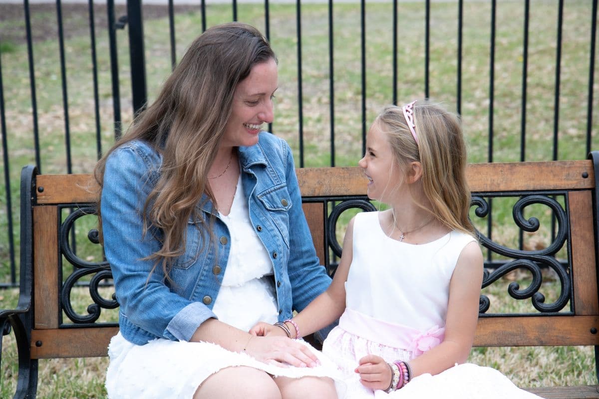 Mother and daughter laughing together on a bench
